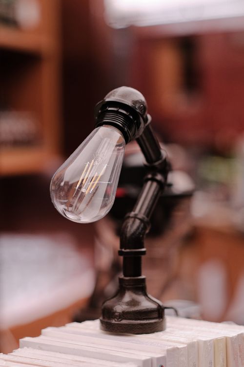 Free Close-up of a vintage industrial desk lamp featuring an Edison bulb, perfect for stylish interiors. Stock Photo