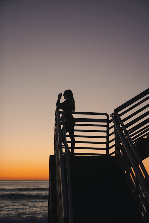 Silhouet Van Een Vrouw Die Tijdens Zonsondergang Op Houten Dok Staat