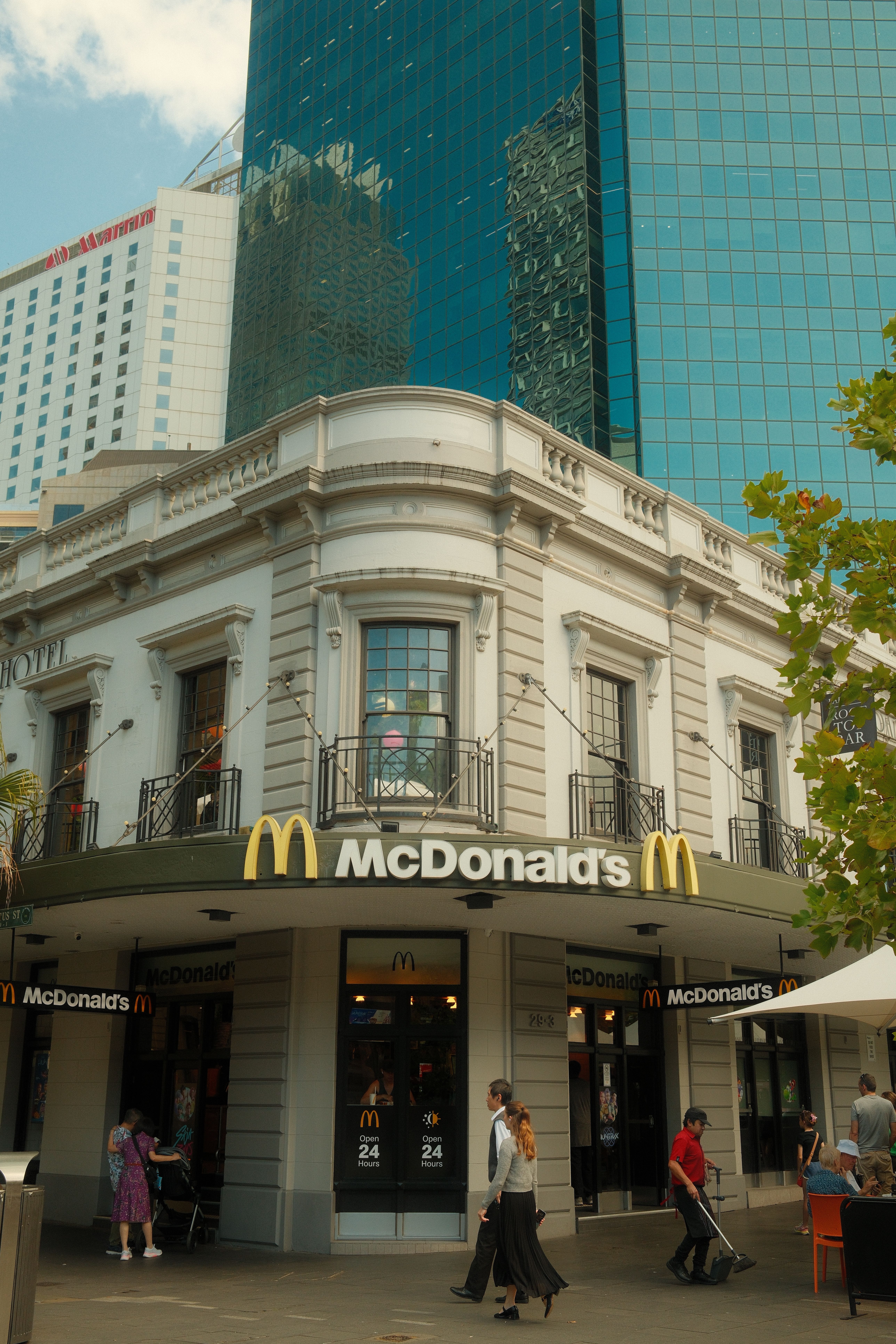Busy McDonald's in Sydney with modern and classic architecture contrast.