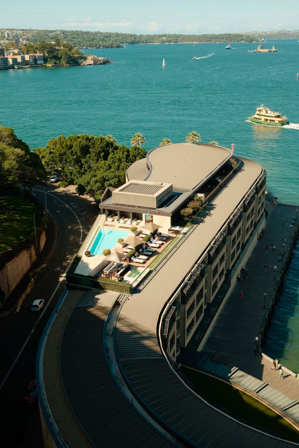 Vista aérea de hotel boutique con piscina en azotea sobre la bahía de Sydney