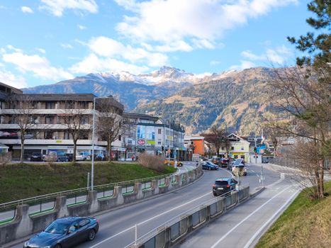 Explore the picturesque cityscape of Lienz with stunning Alpine mountains in the background on a sunny day.