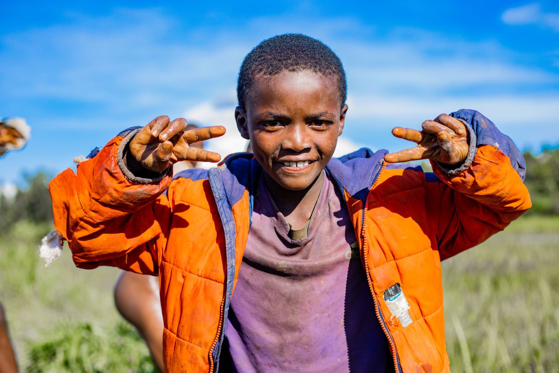 Joyful Child Outdoors with Peace Sign · Free Stock Photo
