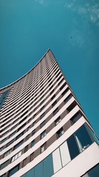 Dynamic urban architecture of a Sarajevo skyscraper under a bright blue sky.