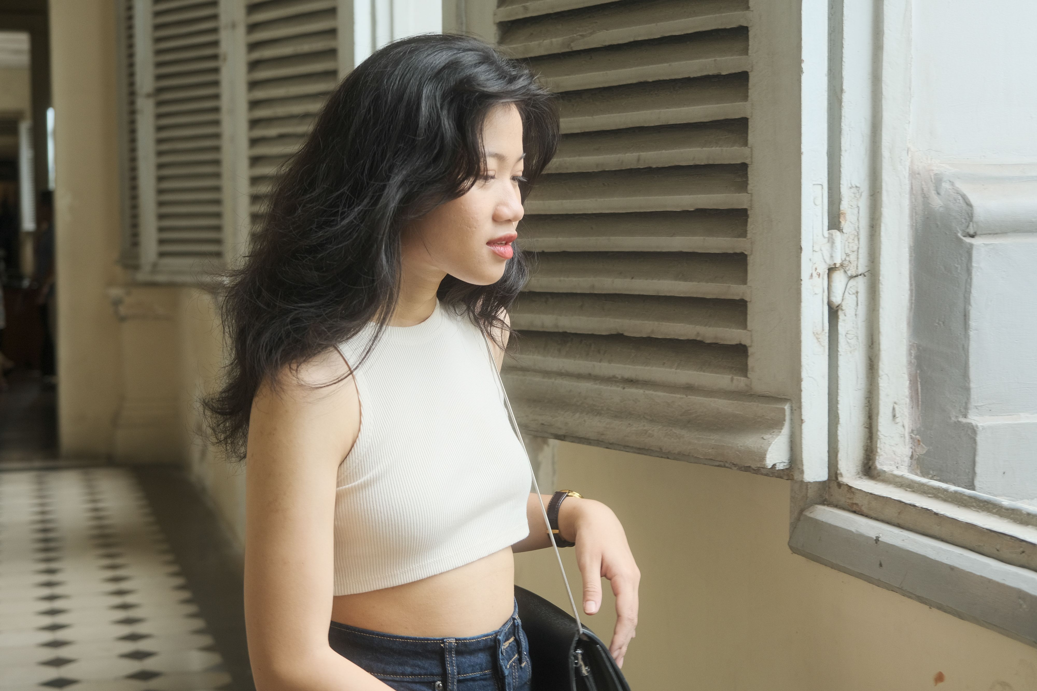 ホーチミン市の窓辺で、物思いにふける若い女性が穏やかなひとときを過ごしている。