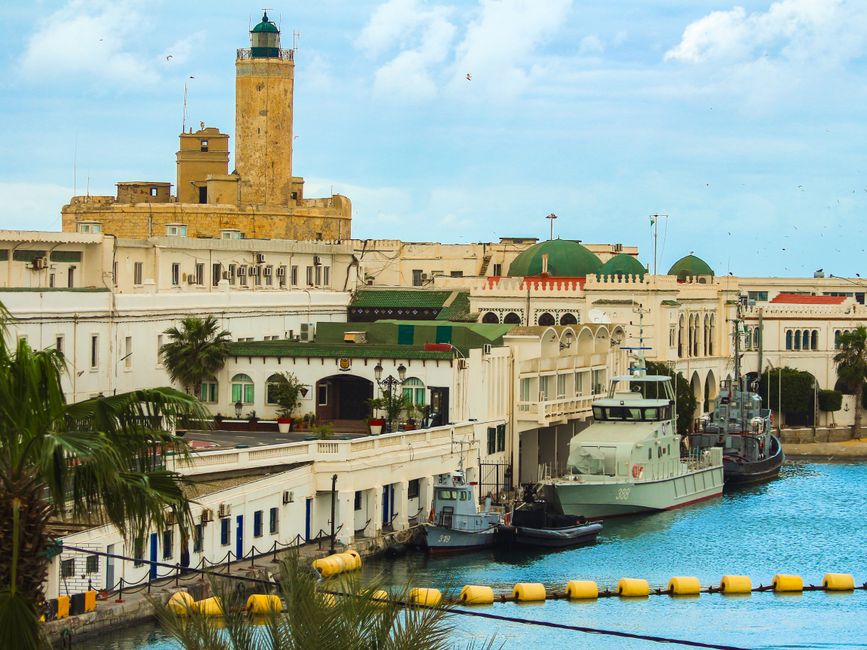 Charming historic buildings and marina view in a coastal North African city under a clear sky.