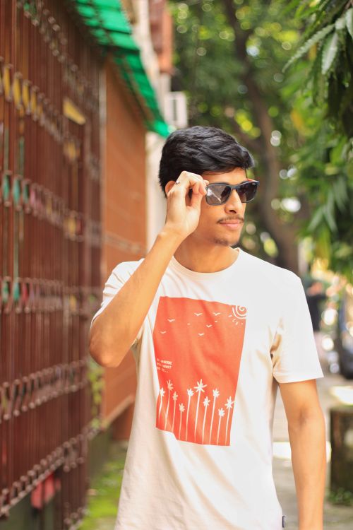 Free Young man in sunglasses walking down a street in Kolkata, India, showcasing urban fashion. Stock Photo