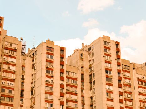 View of high-rise apartment buildings with a blue sky backdrop, showcasing urban architecture.