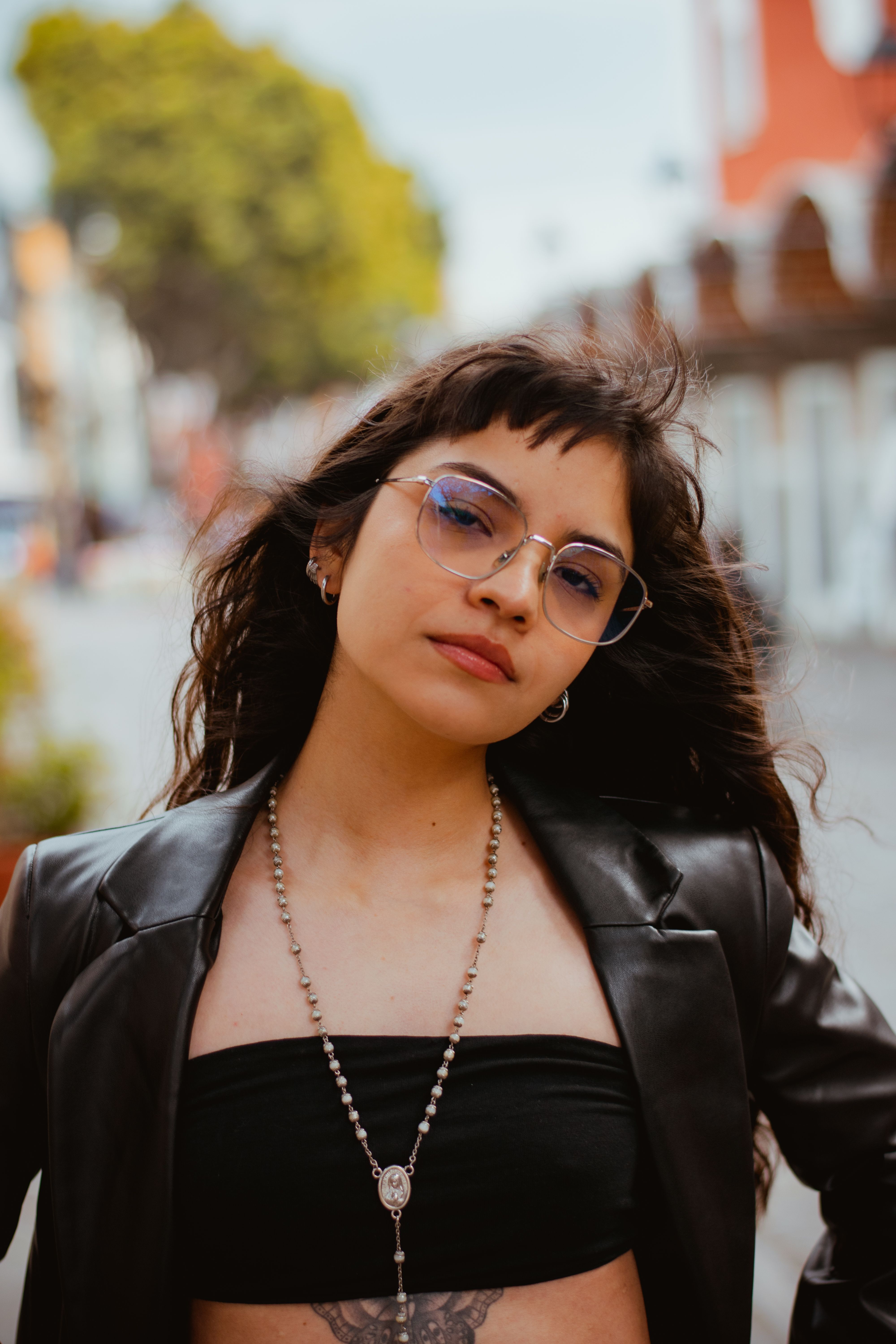 Portrait of a fashionable woman outdoors in Puebla, showcasing modern style with urban backdrop.