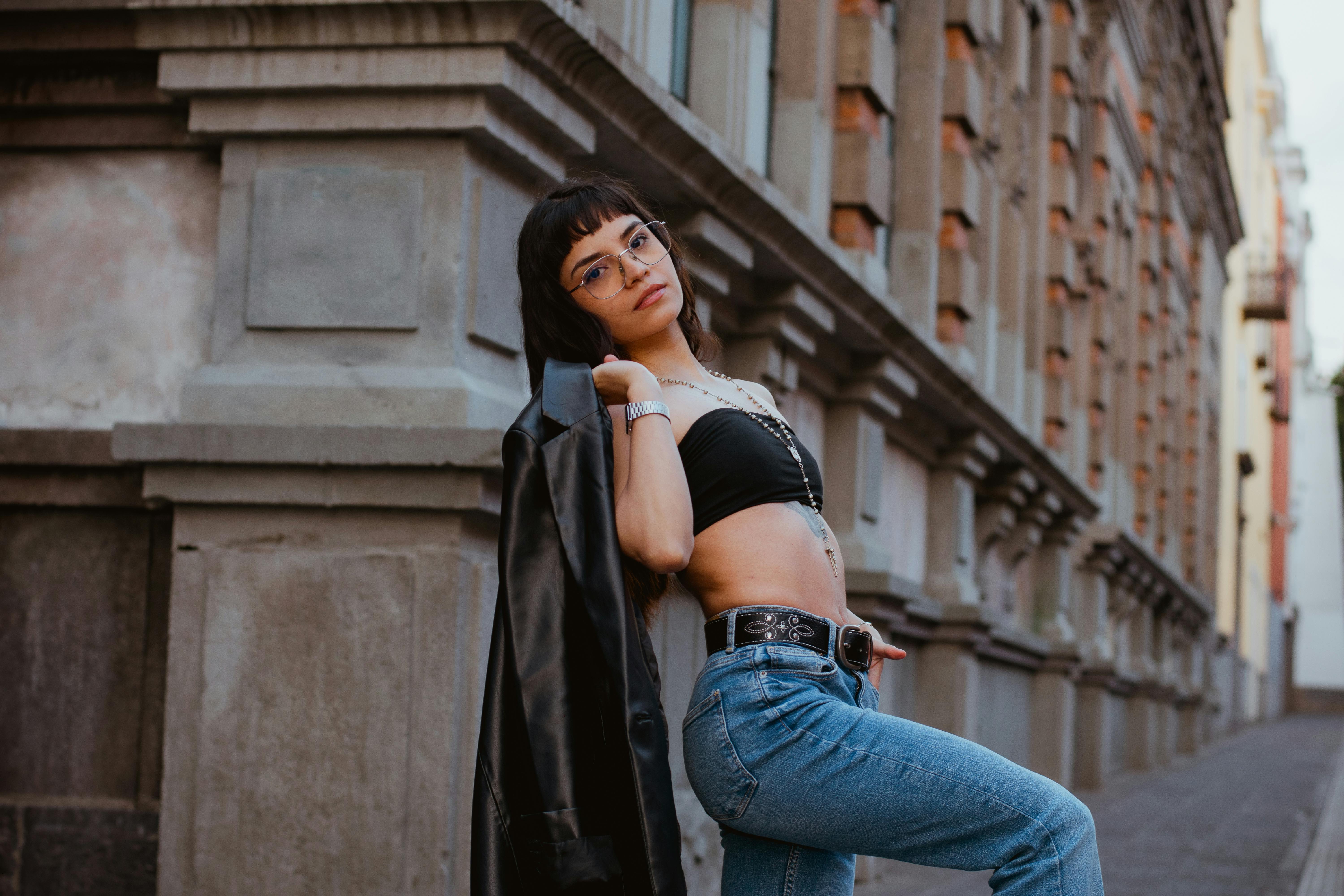 A stylish woman poses confidently against a historic building in Puebla, Mexico.
