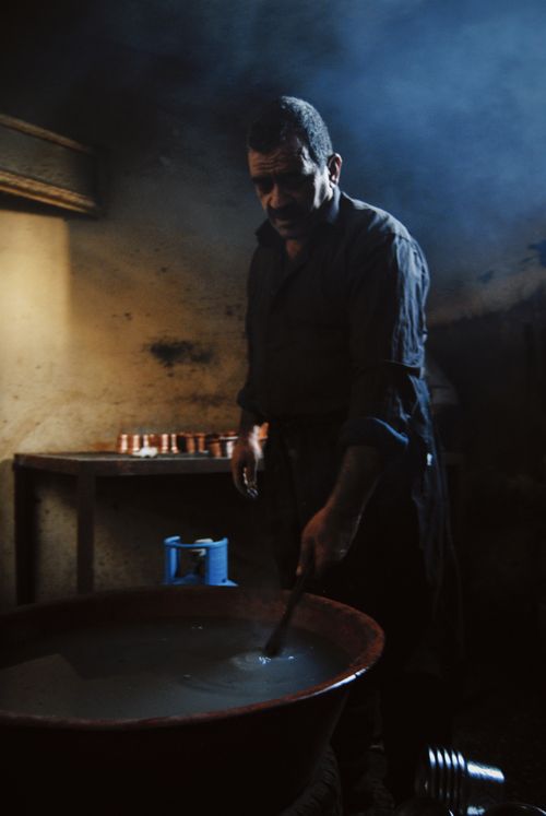 Free A craftsman working in a traditional workshop with a moody atmosphere. Stock Photo