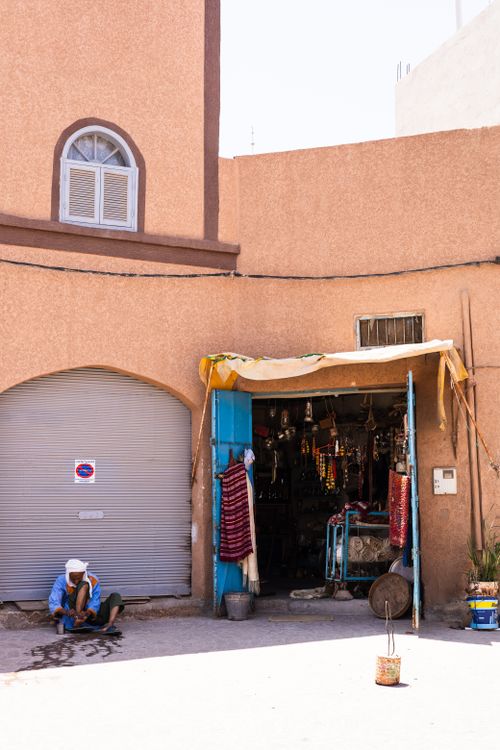 Free A local artisan and shop in Tiznit, Morocco showcasing traditional crafts and textiles on a sunny day. Stock Photo