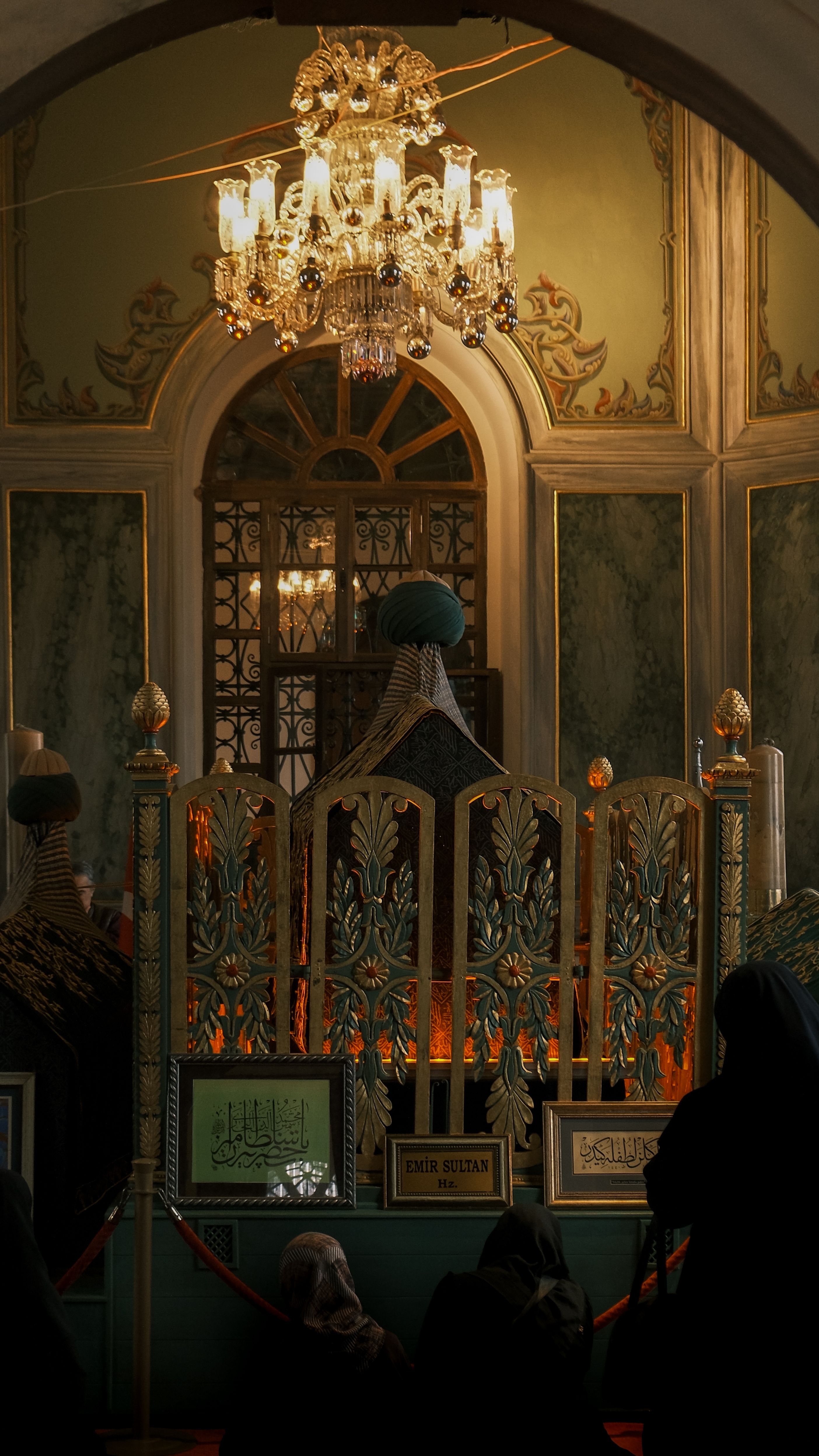 Interior of a historic building with ornate details and chandelier, showcasing architectural elegance and cultural significance.