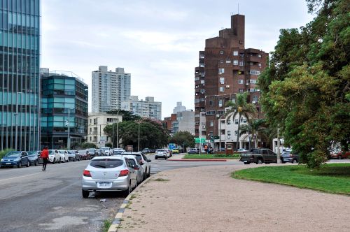 Free Street view in Montevideo with modern and traditional buildings, cars, and greenery. Stock Photo