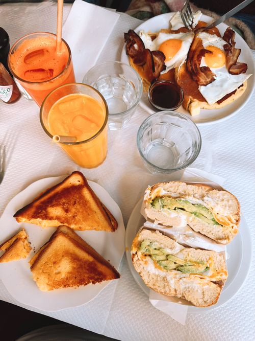 Free Top-down view of a breakfast spread with juices, sandwiches, and toast on a table. Stock Photo