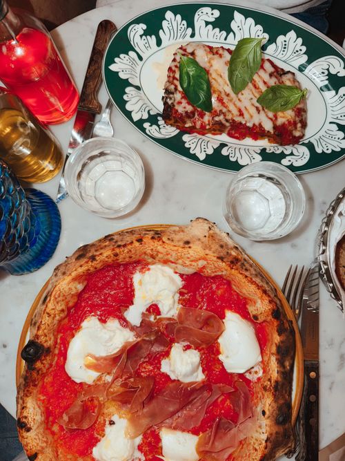 Free Top view of Italian pizza with ricotta and eggplant parmesan on a marble table. Stock Photo