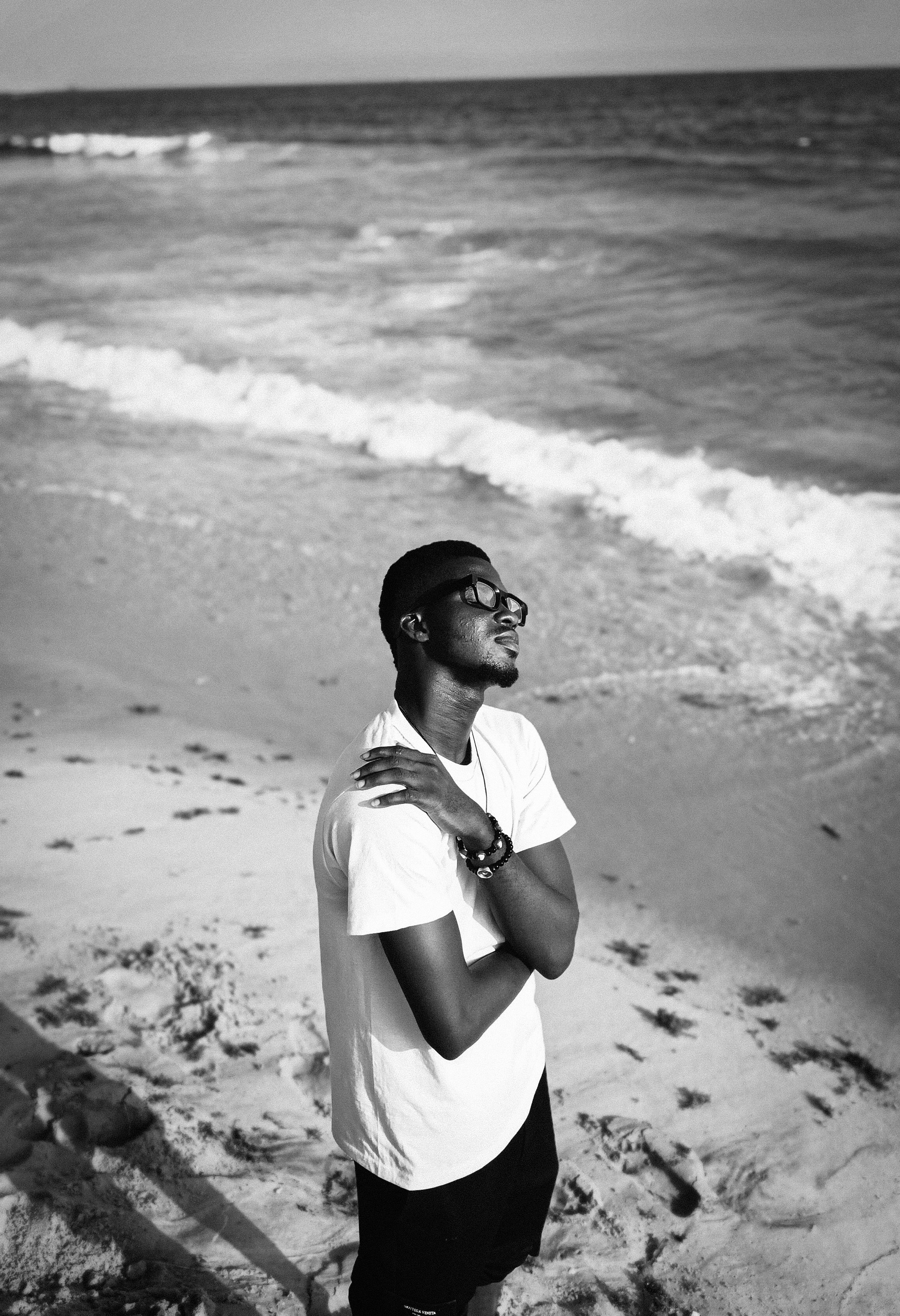 Black and white photo of a young man enjoying a tranquil beach in Lagos, Nigeria.