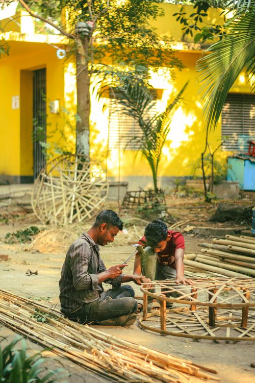 Free Artisans crafting bamboo structures outdoors in Dhaka, Bangladesh, highlighting traditional skills. Stock Photo