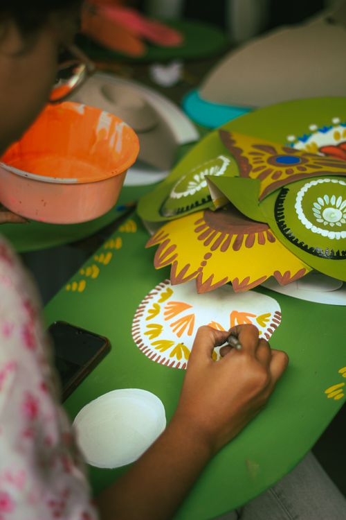 Free Close-up of an art student painting vibrant patterns on a green canvas in Dhaka, Bangladesh. Stock Photo