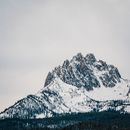白雪皑皑的雄伟山峰映衬着多云的冬日天空，景色令人惊叹