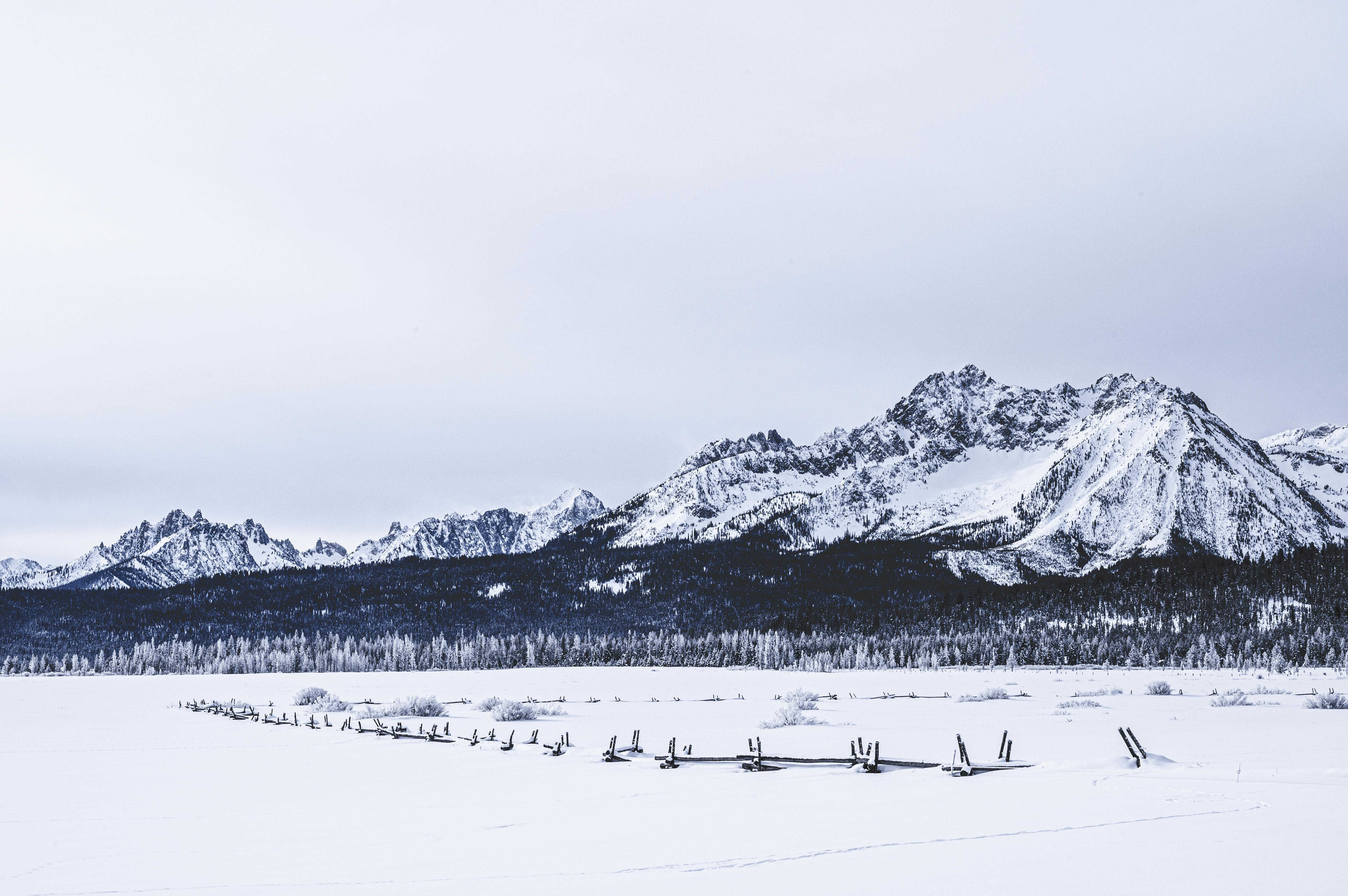 白雪皑皑的山脉与阴云密布的天空，共同勾勒出冬季宁静景观的美丽