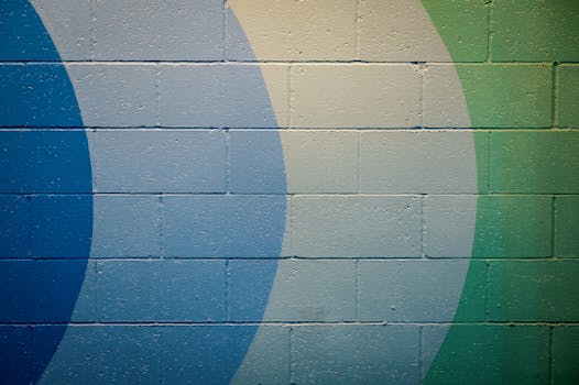 水泥墙上绘有生动的抽象壁画，图案是蓝色和绿色的几何图形