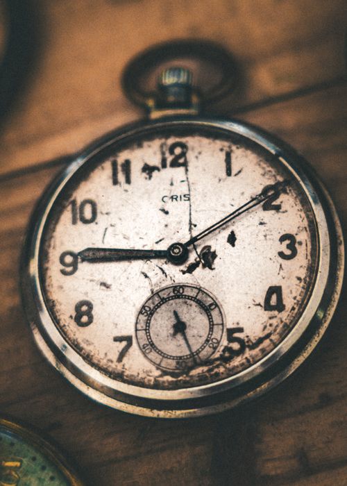 Free Close-up of a weathered vintage pocket watch displaying a nostalgic and rustic charm. Stock Photo