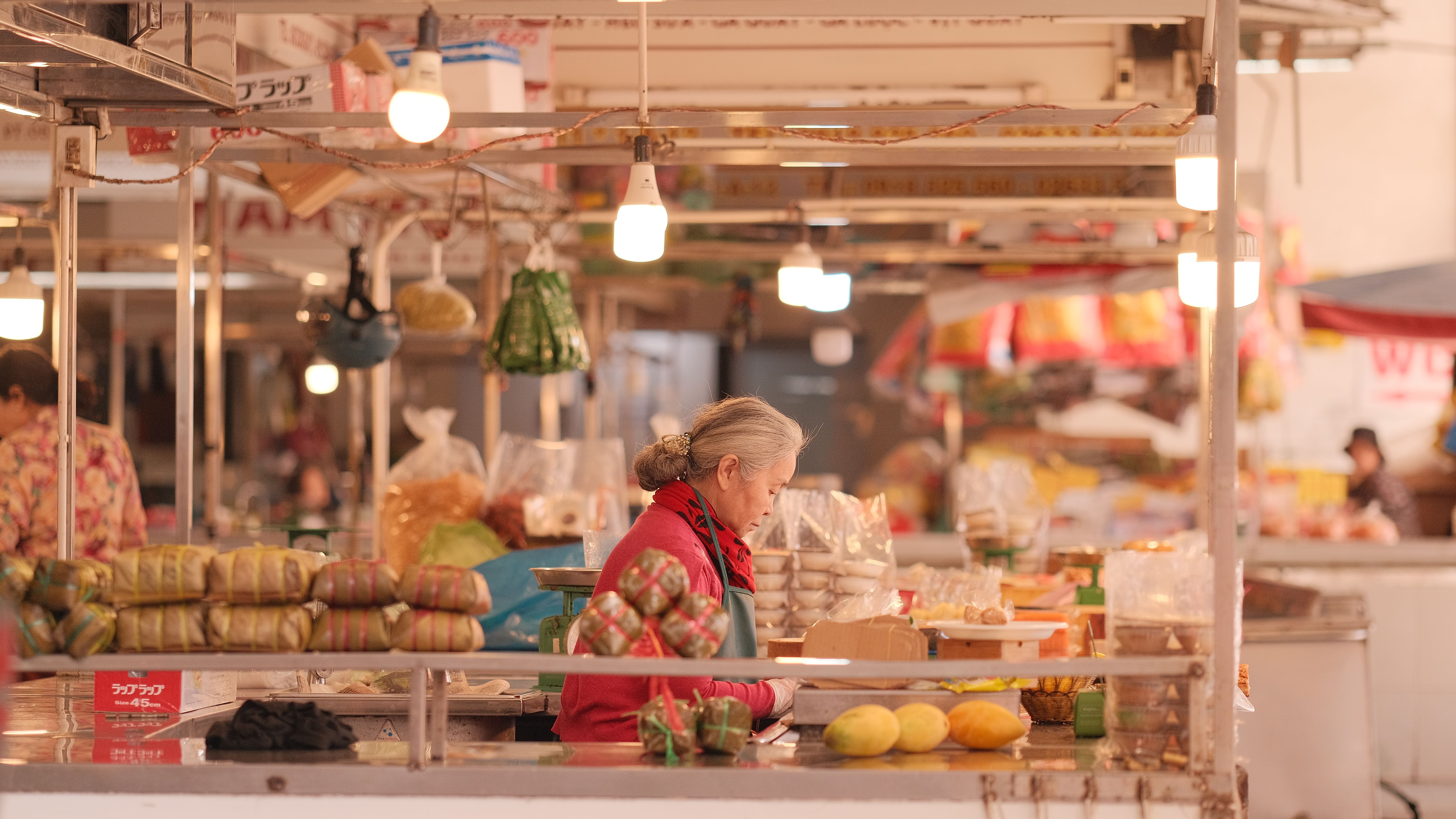 A vendor at a bustling Asian food market