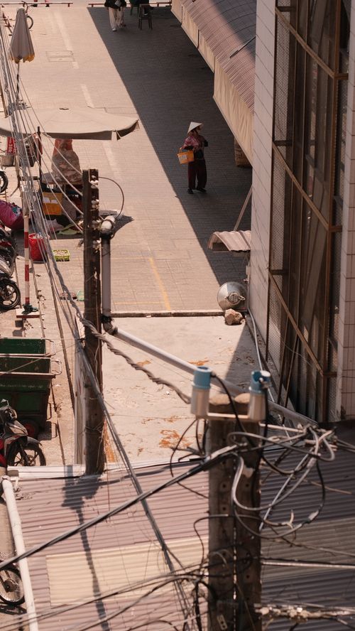 Free Aerial view of a city street with a person wearing a conical hat, showcasing urban lifestyle. Stock Photo