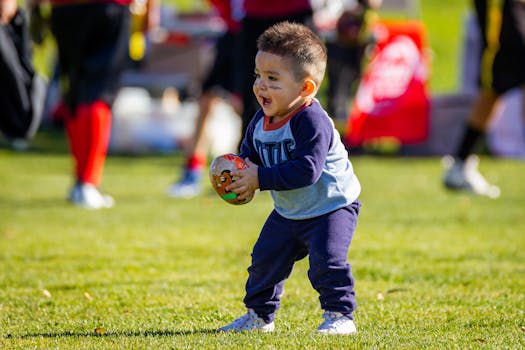 Boy in Purple Long Sleeves Shirt and Purple Pants Holding Brown Football