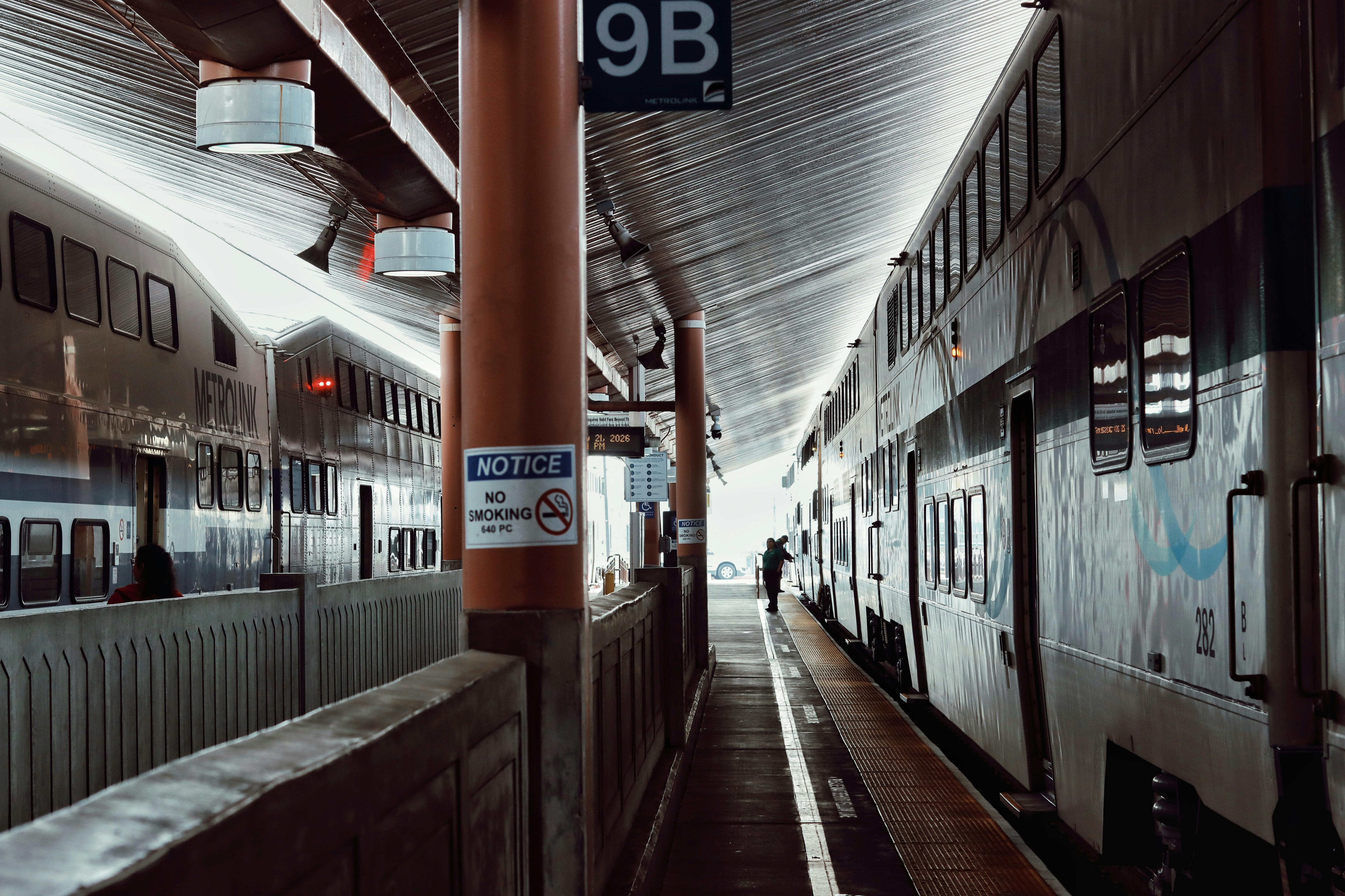 Two commuter trains at a Los Angeles station platform, showcasing bustling urban transit.