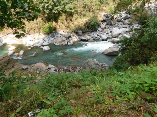Free A scenic river flows through a lush, rocky landscape, surrounded by greenery. Stock Photo