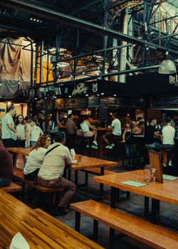 Captivating indoor scene of people dining and shopping at vibrant San Telmo Market in Buenos Aires.