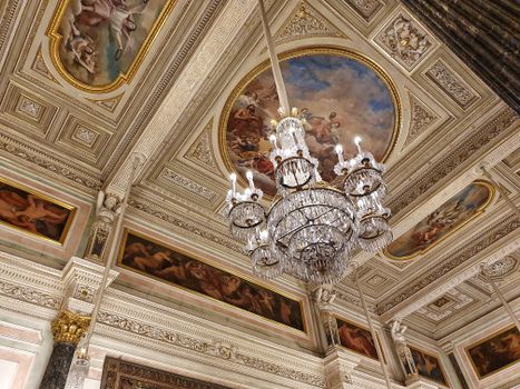 Intricate Baroque style ceiling with chandelier in a grand art museum interior.