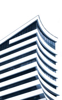 Dynamic view of a modern building with distinctive curved architecture and glass windows.