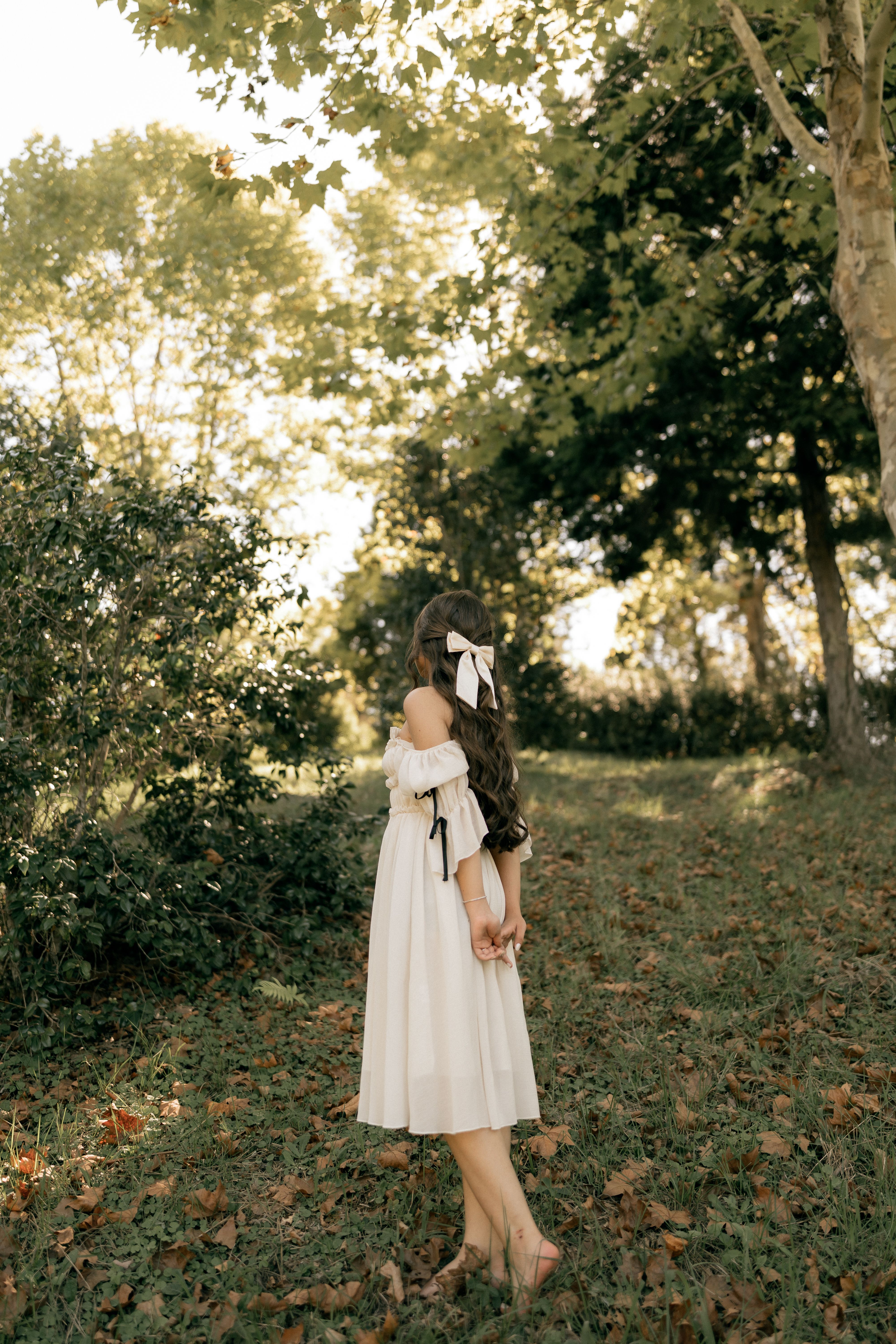 Two Girls with Bows in Floral Dresses Outdoors · Free Stock Photo