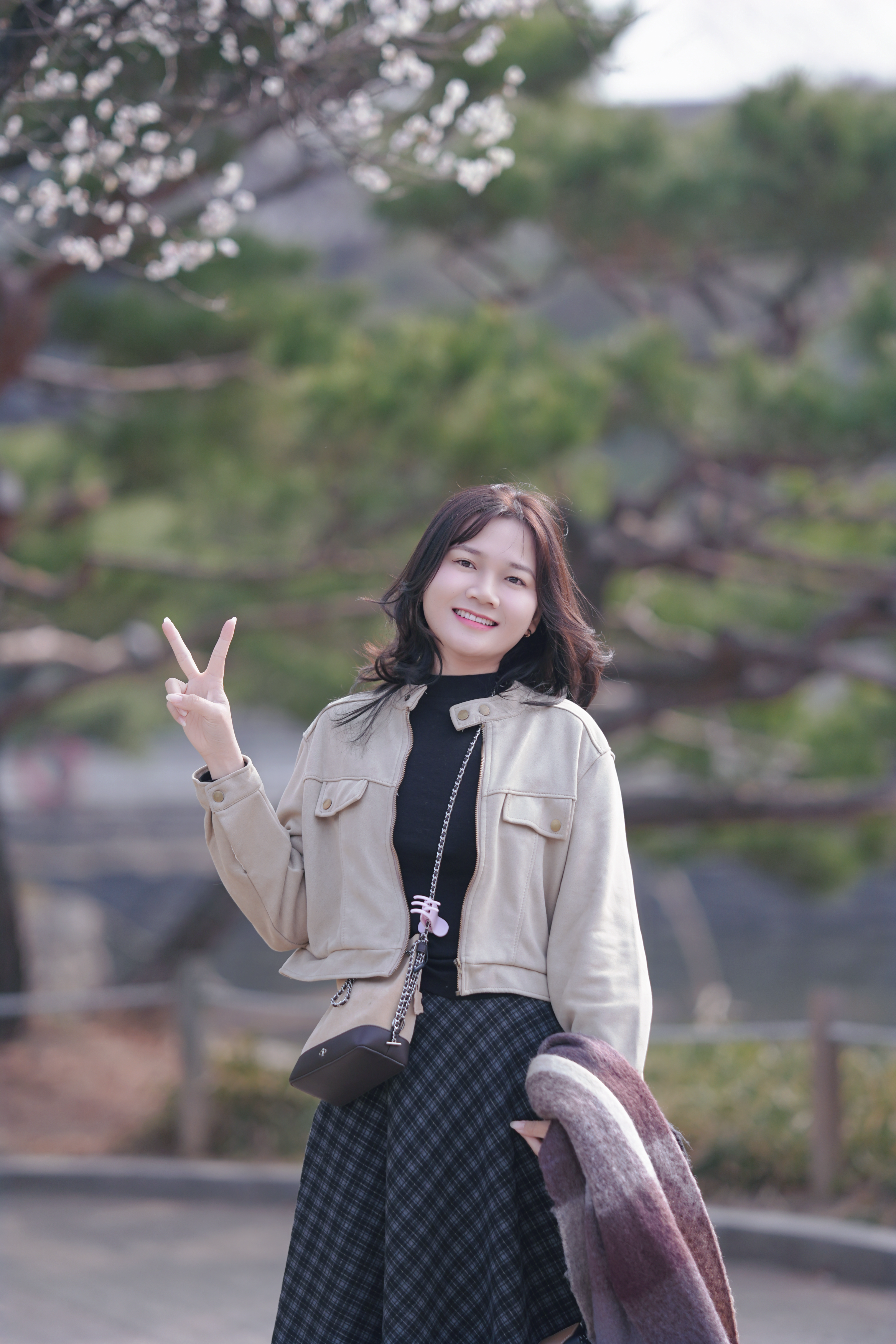 Cheerful Woman Posing with Peace Sign Outdoors · Free Stock Photo