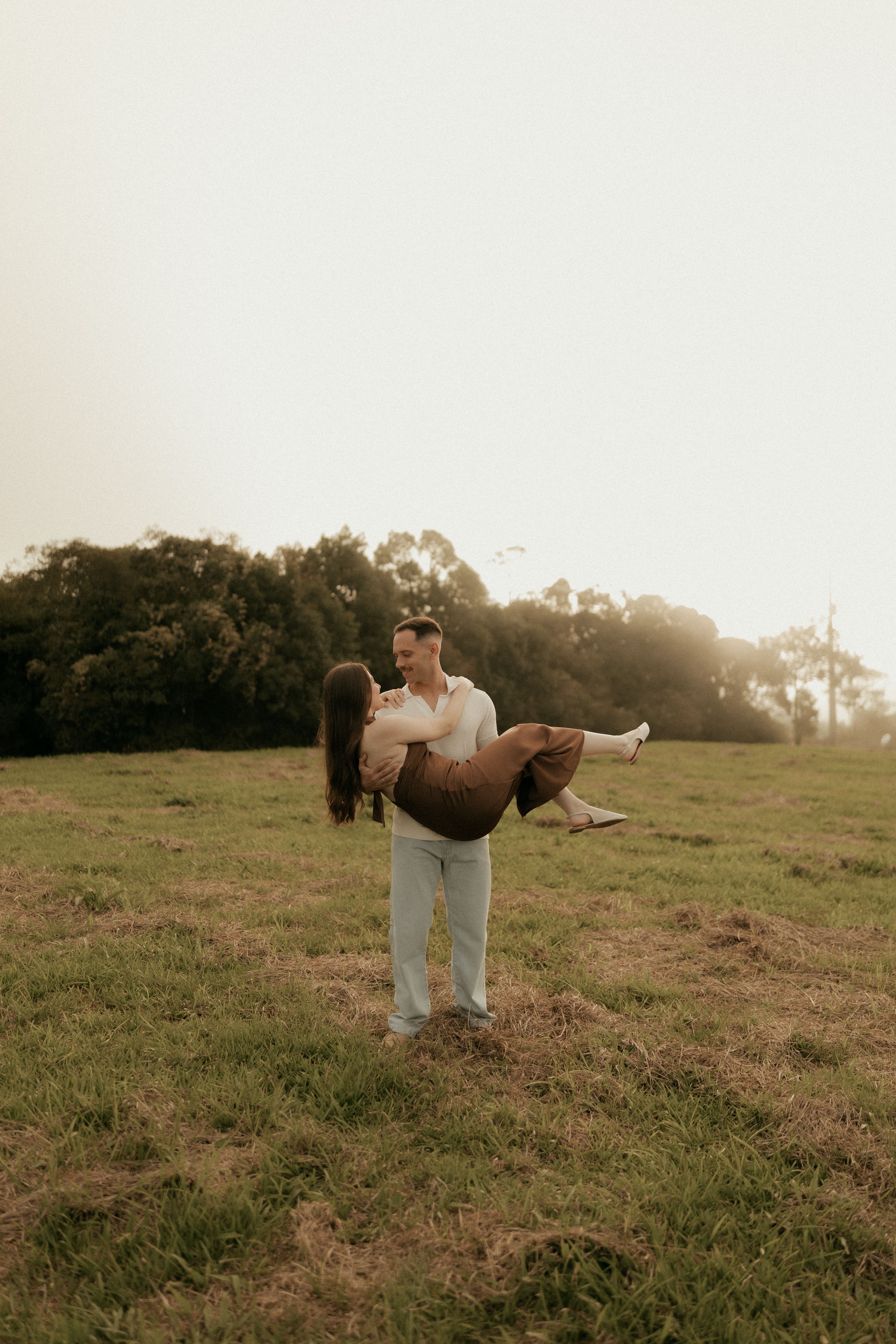 Romantic Couple Embracing in Sunlit Field · Free Stock Photo