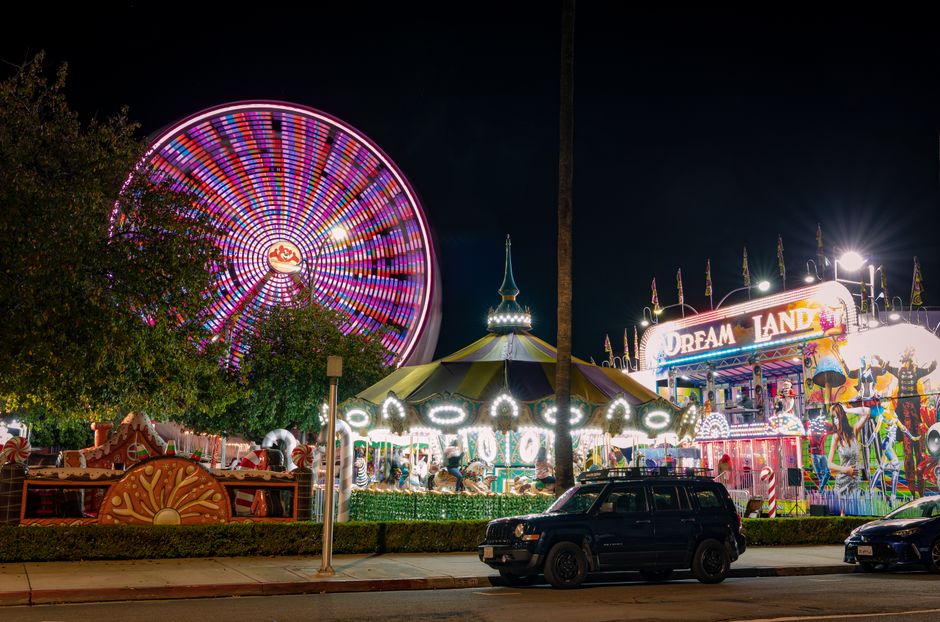Vibrant nighttime image of a carnival with a Ferris wheel and carousel in Riverside, California.
