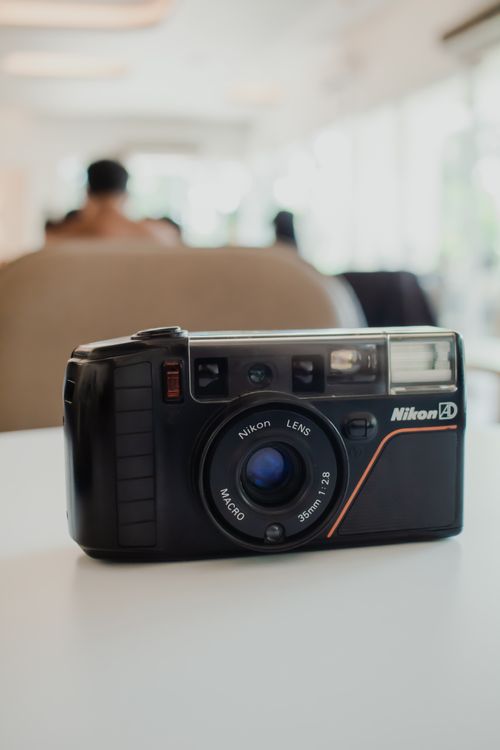 Free Classic Nikon film camera with macro lens in a cozy indoor setting. Stock Photo