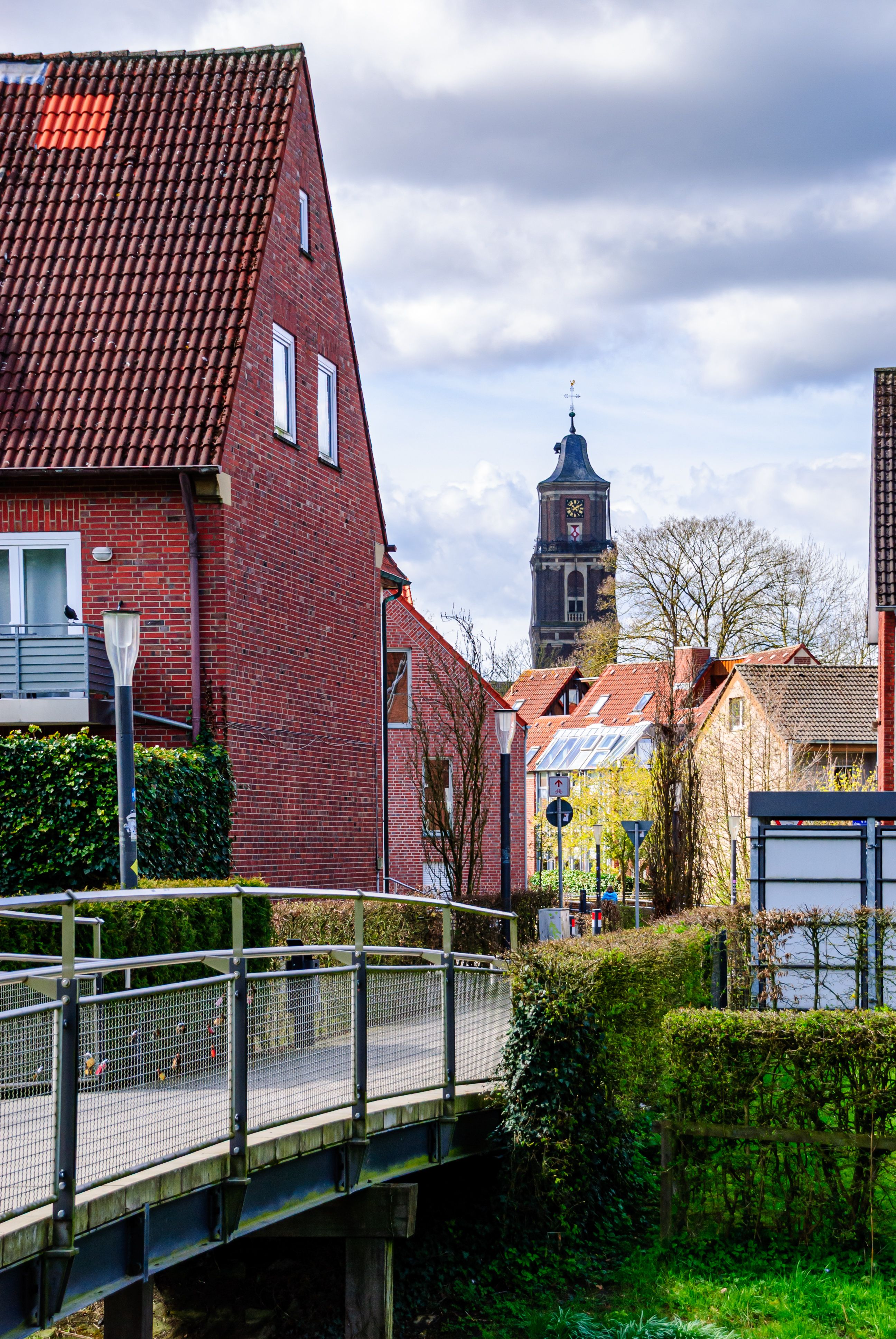 Picturesque street with traditional German architecture in Coesfeld, showcasing a church tower and bright sky.