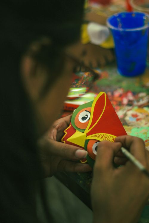 Free Close-up of a person painting a traditional Bengali mask at Dhaka University. Stock Photo