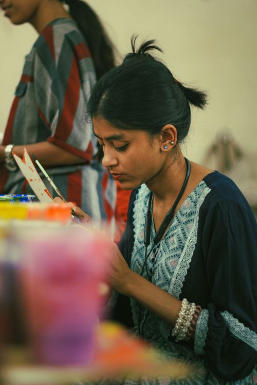 Free Focused young woman painting in an art class at Dhaka, capturing creativity and concentration. Stock Photo