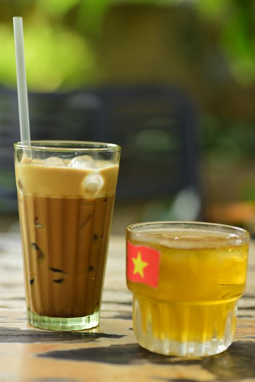 Free A refreshing glass of Vietnamese iced coffee accompanied by a cup of iced tea. Stock Photo
