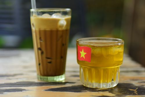 Free Iced Vietnamese coffee and tea glasses on a rustic table outdoors. Stock Photo