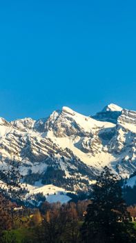 Stunning photo of snow-capped mountains in the Alps on a clear, sunny day, showcasing natural beauty.