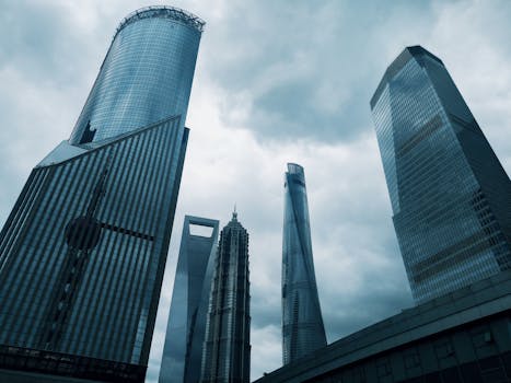 高耸的未来主义摩天大楼在阴云密布的天空下，展现出戏剧性的城市景观