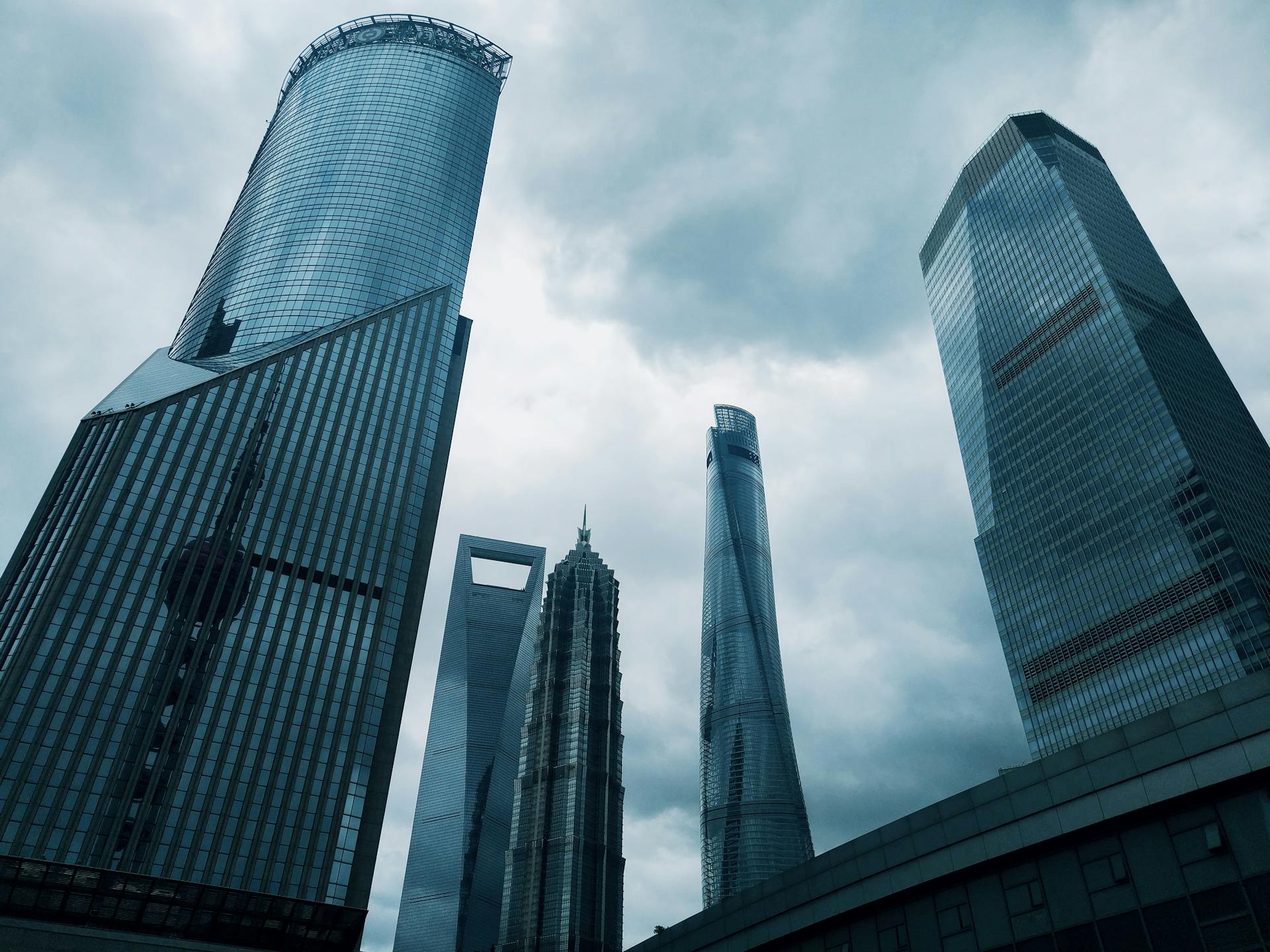 Dramatic cityscape showcasing towering futuristic skyscrapers under a cloudy sky.