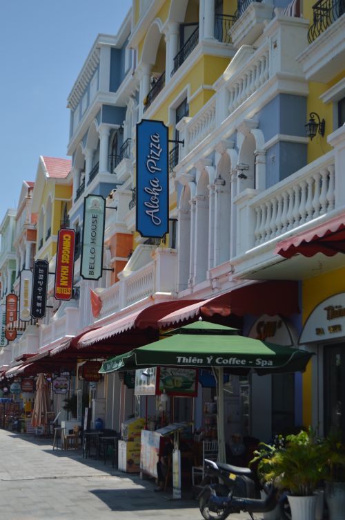Free Vibrant shops and cafes line a sunny street, ideal for tourists. Stock Photo
