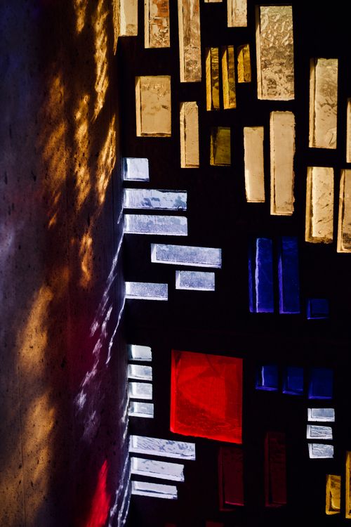 Free Colorful abstract design created by light filtering through geometric stained glass windows. Stock Photo