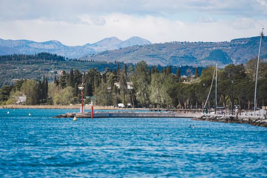 Picturesque view of Lake Garda with mountains and lush greenery surrounding the area.